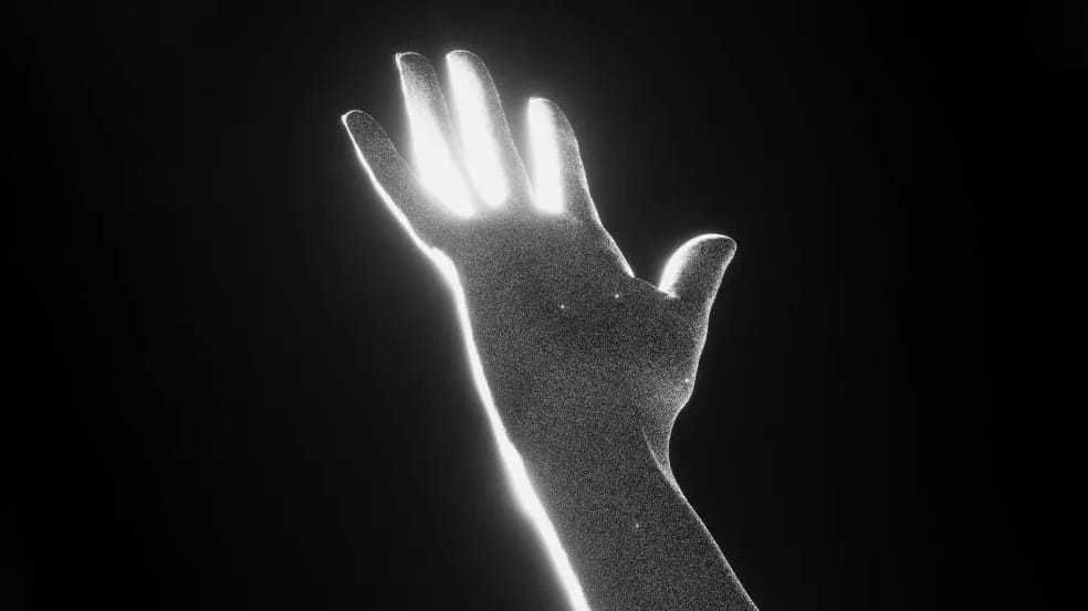 A hand reaching into space. It has a grain effect applied and the lighting makes it look heavenly.