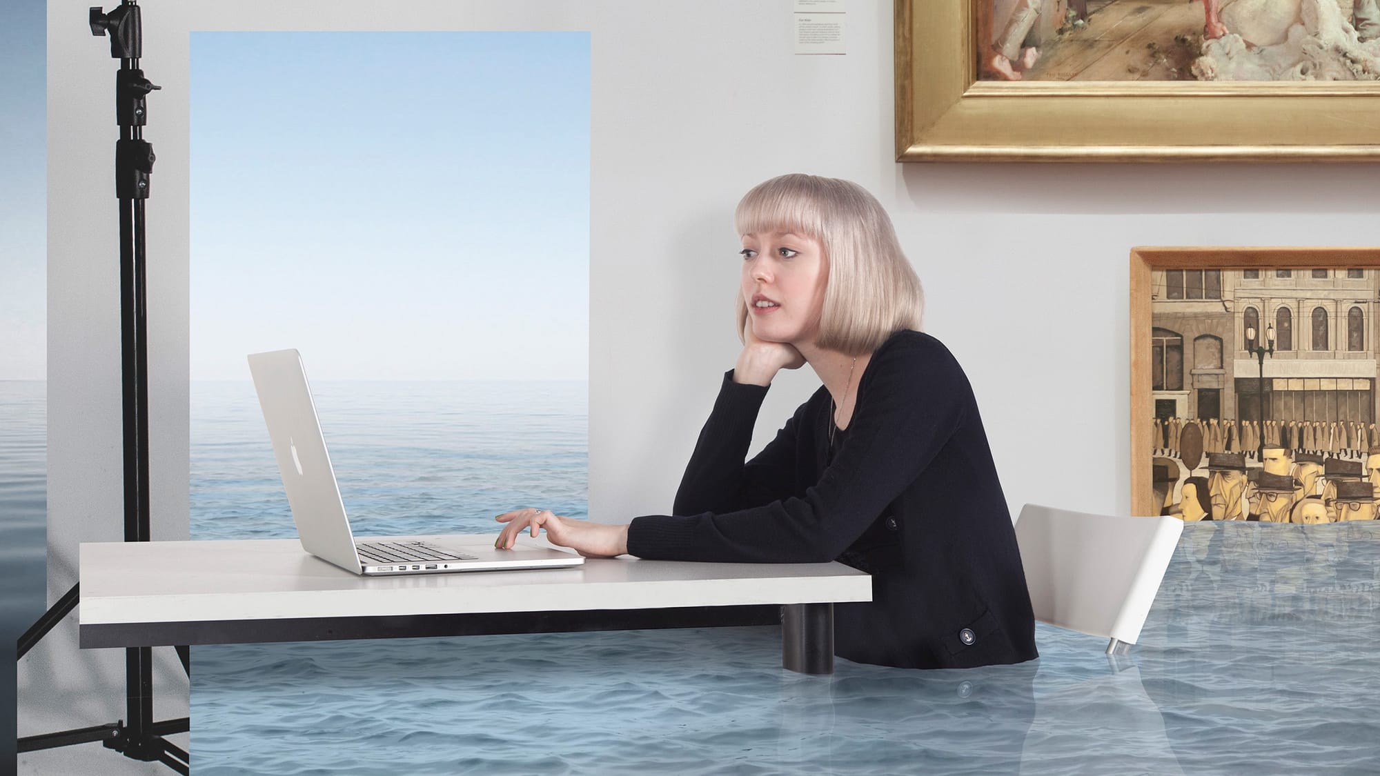 A woman at a desk using her laptop while the room fills with water